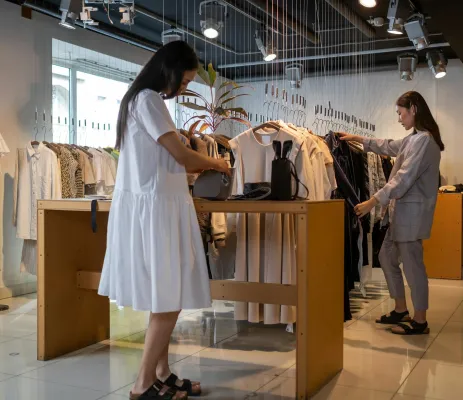 twee dames die kleding uitzoeken in een kledingwinkel